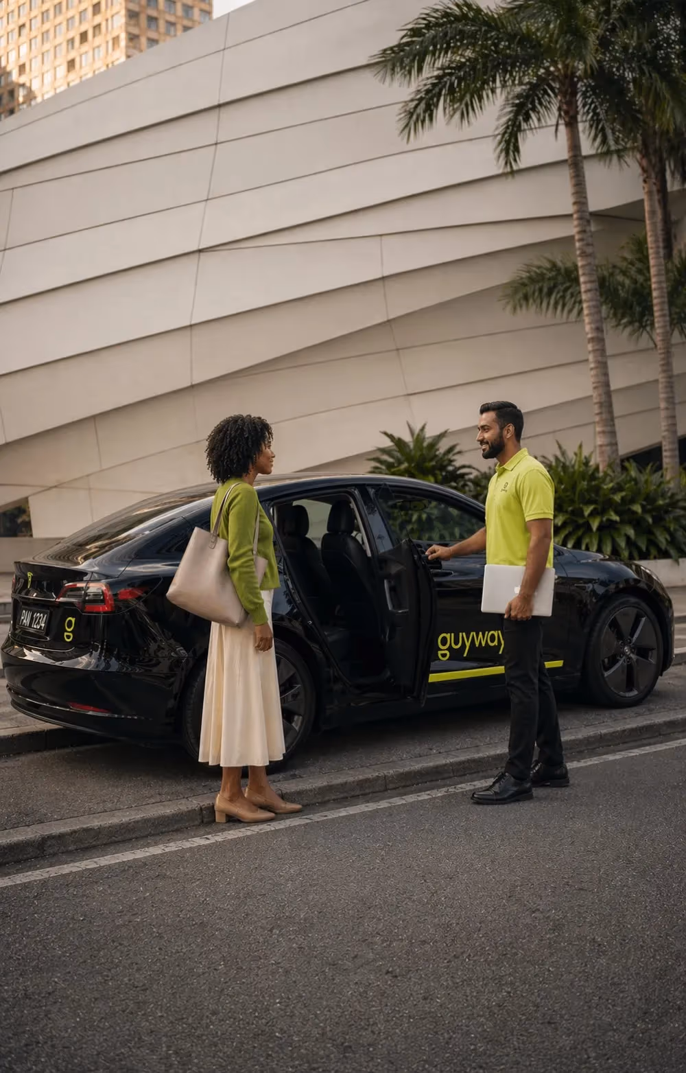 A GuyWay driver in a branded yellow polo opens the rear door of a black GuyWay-branded Tesla for a rider on a Georgetown street — vetted drivers, trackable trips, and a real local safety team on every ride