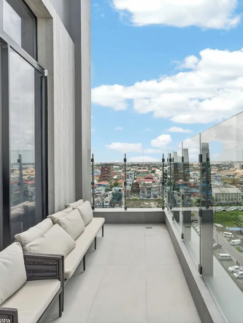 A modern corporate rooftop balcony overlooking the Georgetown skyline at midday — GuyWay for Business powers executive travel for Guyana's corporate and oil-sector clients