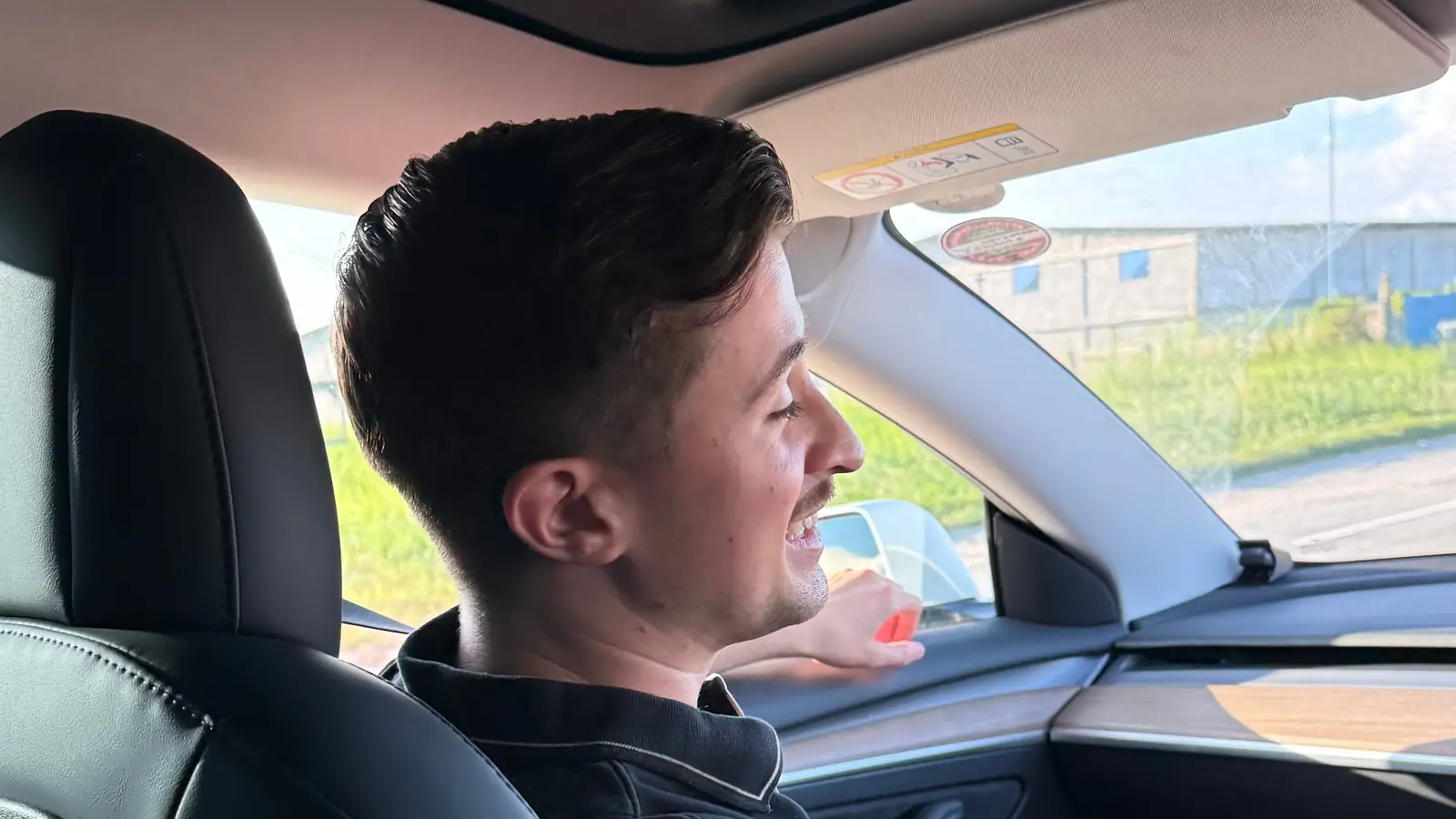 A young passenger in the back seat of a GuyWay Tesla