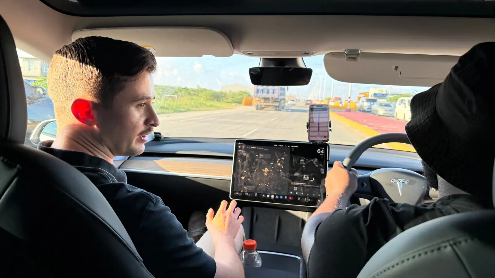 Interior de un Tesla de GuyWay en marcha: un pasajero en el asiento delantero junto al conductor