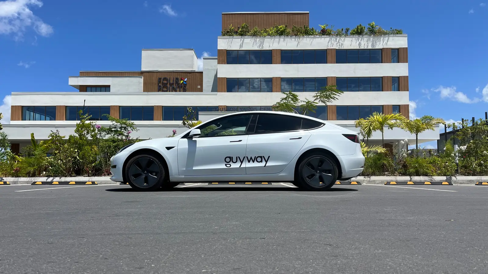 White GuyWay Tesla Model 3 outside the Four Points hotel in Georgetown