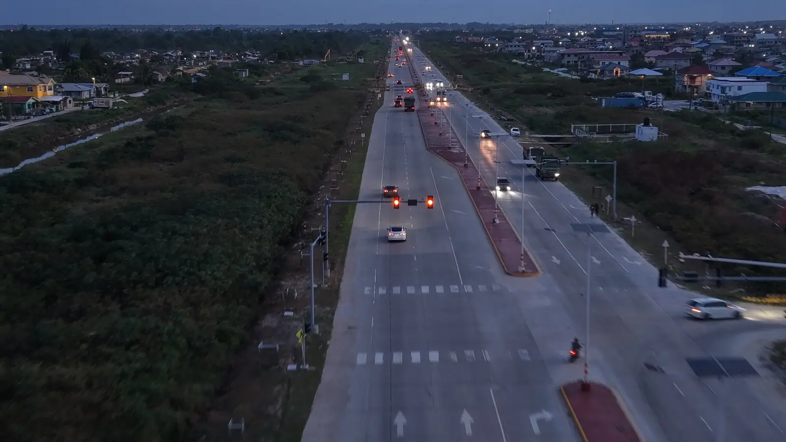 Vista aérea da East Bank Highway ao entardecer, a estrada entre Georgetown e o CJIA
