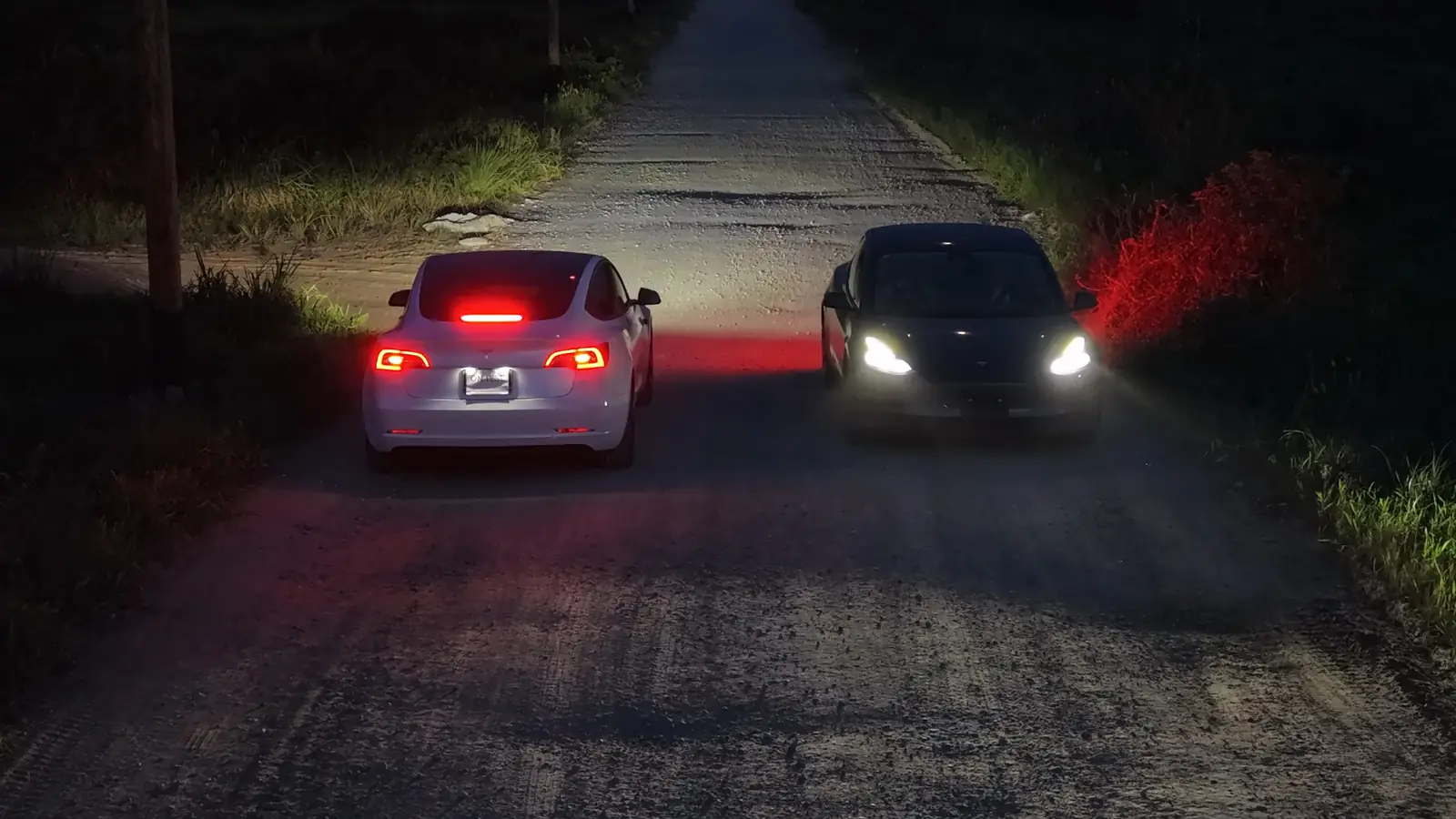 Dos Tesla de GuyWay en un camino secundario de noche, vistos desde arriba